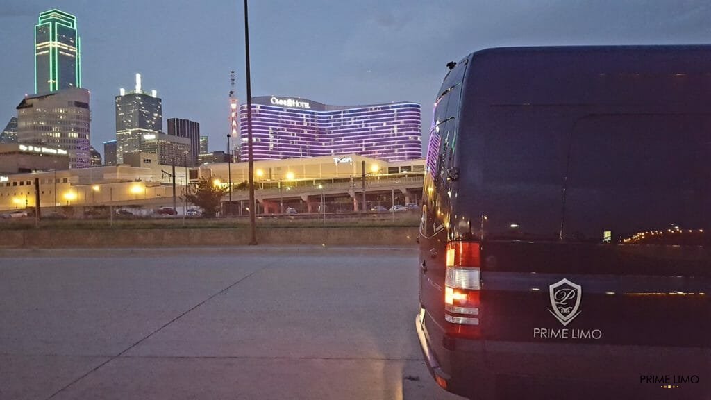 Side of black Sprinter with Omni Downtown Dallas background